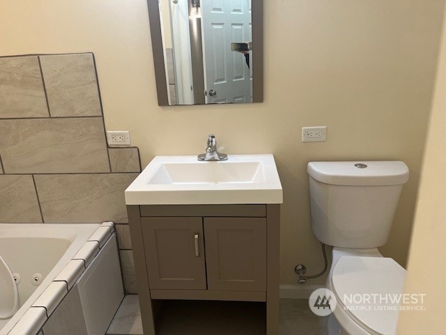 bathroom featuring vanity, toilet, and a bath