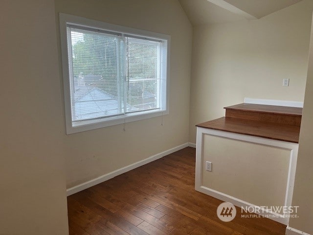 interior space featuring multiple windows, lofted ceiling, and hardwood / wood-style floors