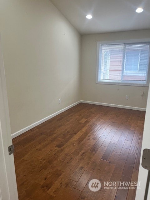 spare room featuring dark wood-type flooring