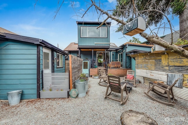 back of property with an outdoor fire pit