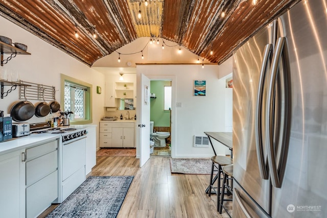 kitchen with white cabinetry, light wood-type flooring, stainless steel refrigerator, wooden ceiling, and electric stove