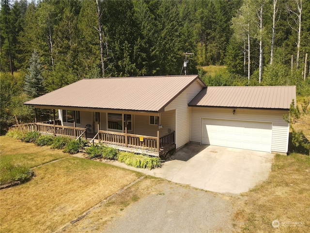 view of front of home featuring a porch, a garage, and a front yard