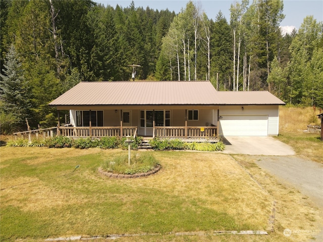 view of front of house with a porch, a garage, and a front lawn