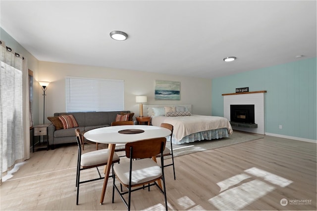 bedroom with a fireplace and light hardwood / wood-style floors