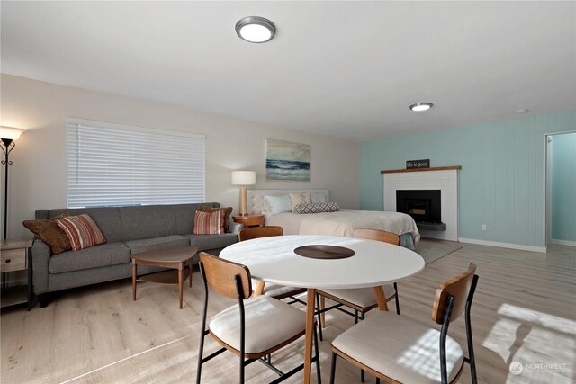 dining room with a brick fireplace and light wood-type flooring