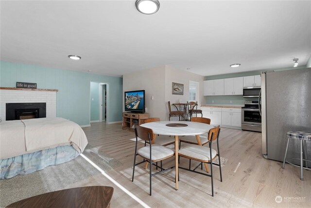 interior space featuring a brick fireplace and light hardwood / wood-style flooring