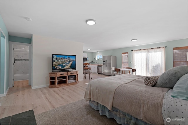 bedroom featuring stainless steel fridge with ice dispenser and light hardwood / wood-style floors