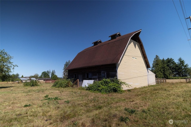 view of side of home with an outbuilding and a yard