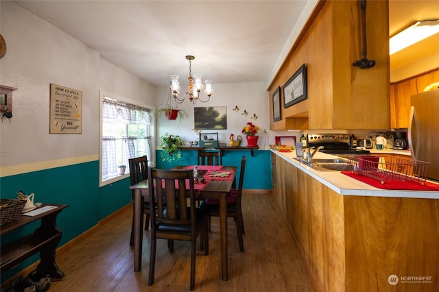 dining room with dark wood-type flooring, sink, and a notable chandelier