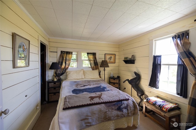 bedroom featuring ornamental molding and wood walls