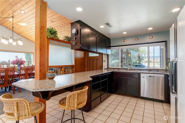 kitchen with light tile patterned flooring, lofted ceiling, stainless steel dishwasher, light stone countertops, and kitchen peninsula