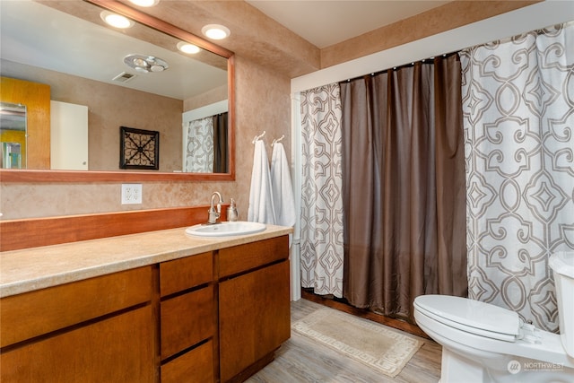 bathroom with wood-type flooring, vanity, and toilet