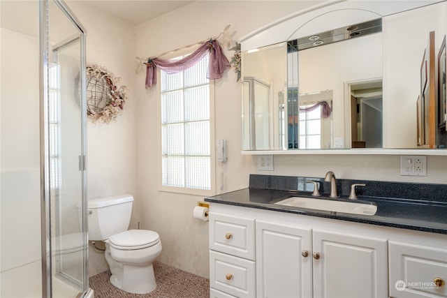 bathroom with vanity, walk in shower, a healthy amount of sunlight, and toilet