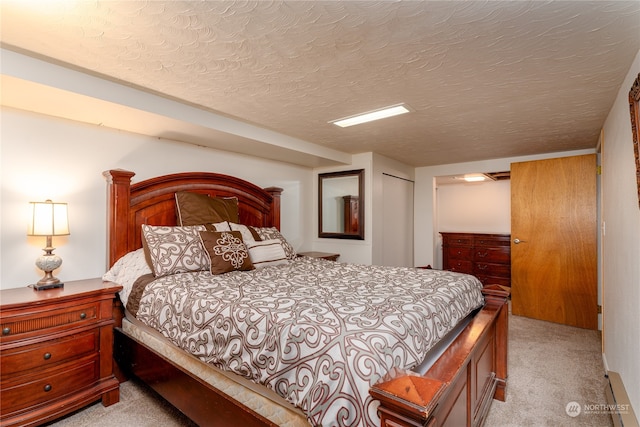 bedroom with a textured ceiling, a closet, and light colored carpet