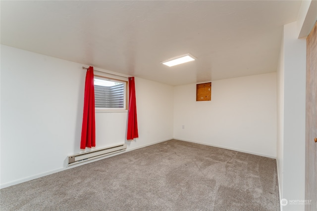 carpeted spare room featuring baseboard heating