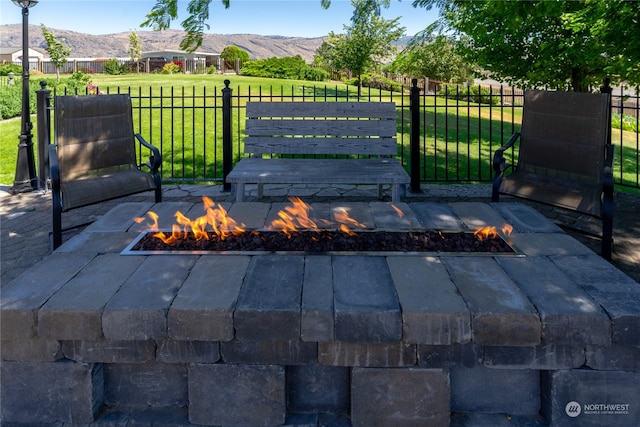 view of patio with a mountain view and an outdoor fire pit