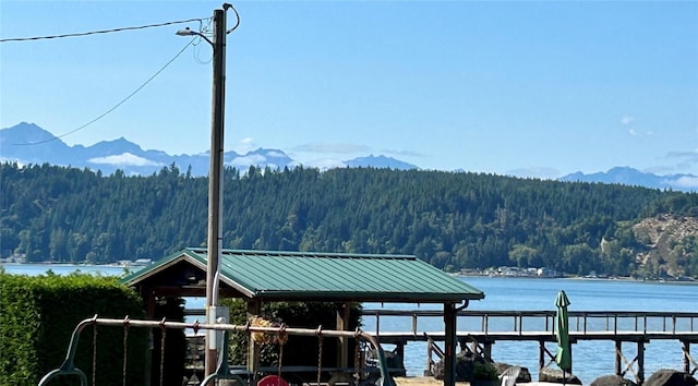 dock area featuring a wooded view and a water and mountain view