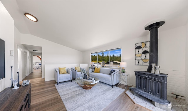 living room with lofted ceiling, hardwood / wood-style floors, and a wood stove