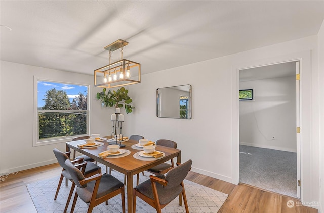 dining space with light wood-type flooring and baseboards