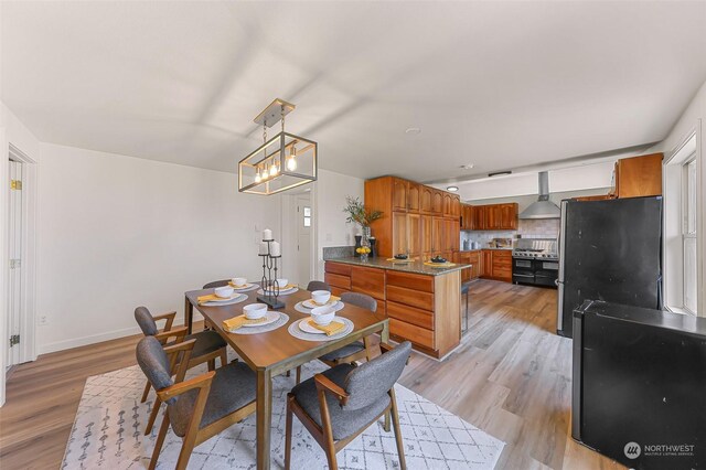 dining space with light hardwood / wood-style floors and an inviting chandelier