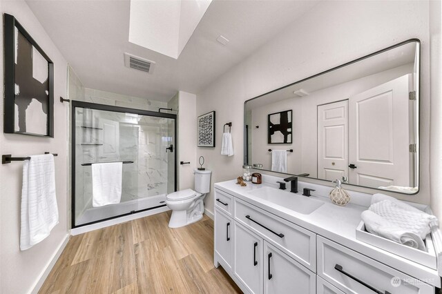 bathroom with toilet, a shower with door, wood-type flooring, and vanity