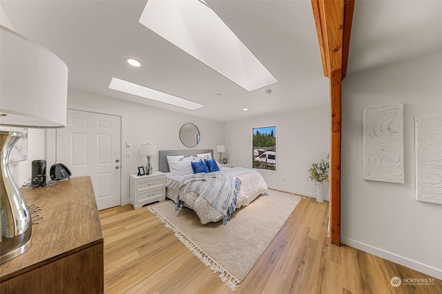 bedroom with light wood-type flooring, a skylight, baseboards, and recessed lighting