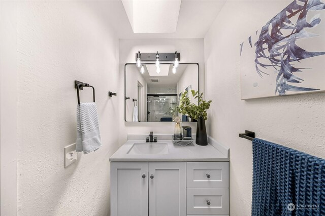 full bathroom featuring a stall shower and vanity