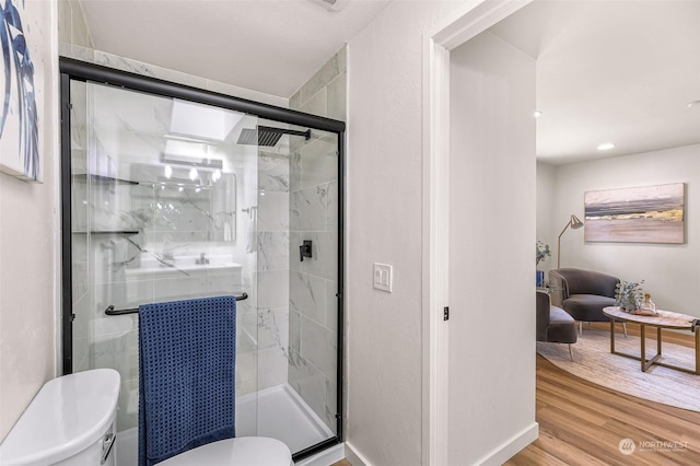 bathroom featuring hardwood / wood-style floors, toilet, and an enclosed shower