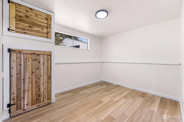 unfurnished room featuring baseboards and wood finished floors