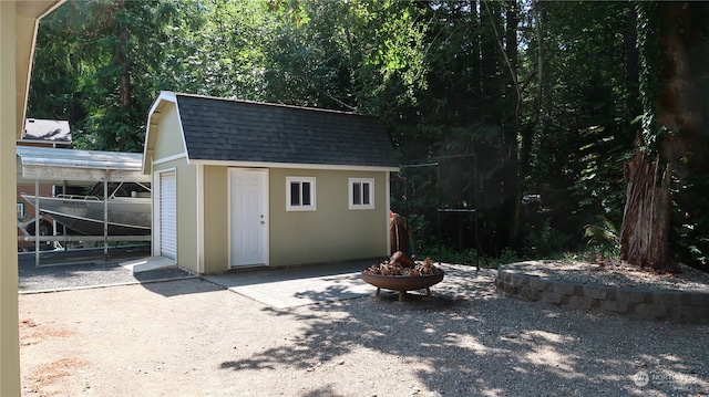 view of outbuilding with an outdoor fire pit