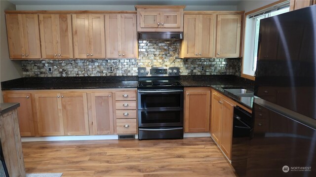 kitchen featuring electric range, dark stone countertops, light hardwood / wood-style flooring, and ventilation hood