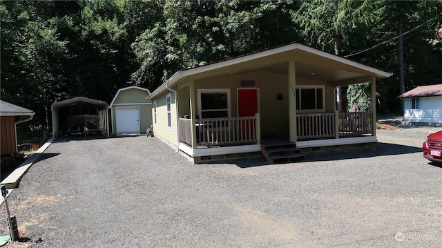 view of front of property featuring a porch, a garage, and an outdoor structure