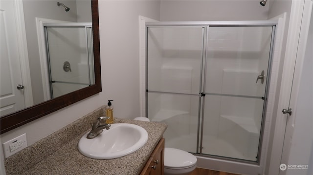 bathroom with vanity, toilet, wood-type flooring, and an enclosed shower