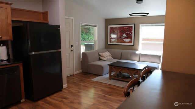 living room featuring lofted ceiling and hardwood / wood-style floors