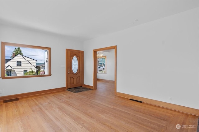 foyer entrance with a chandelier and light hardwood / wood-style flooring