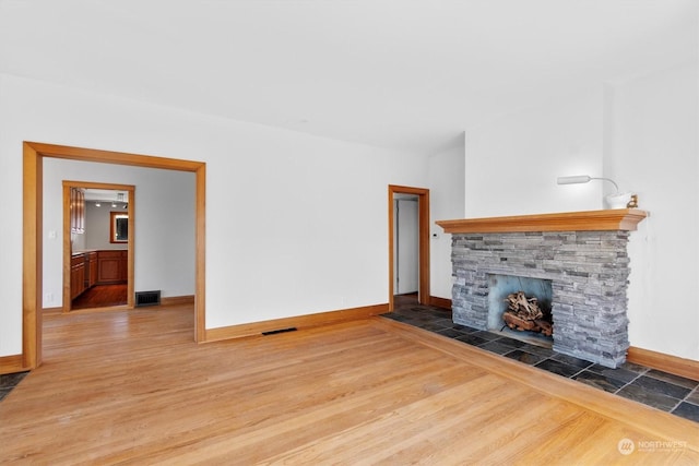 unfurnished living room featuring a fireplace and hardwood / wood-style floors