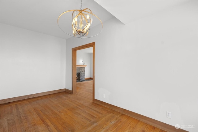 unfurnished room featuring hardwood / wood-style flooring and a notable chandelier