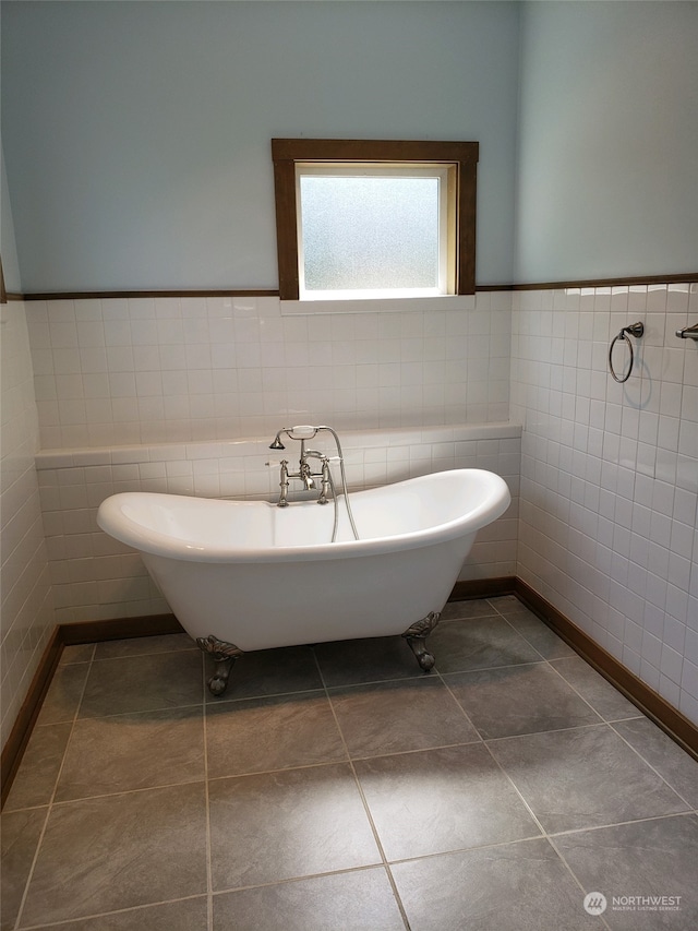 bathroom featuring tile walls, tile patterned floors, and a bathing tub