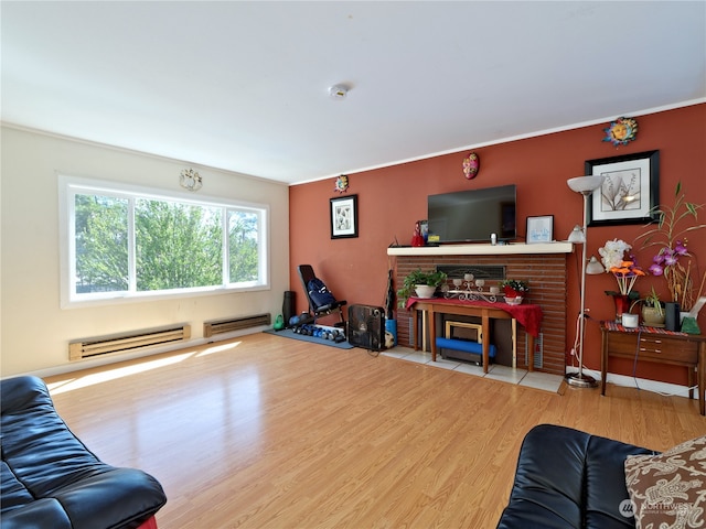 living room with a brick fireplace, a baseboard heating unit, and light wood-type flooring