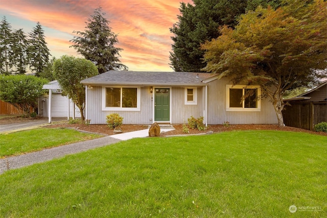 ranch-style house with a garage and a lawn