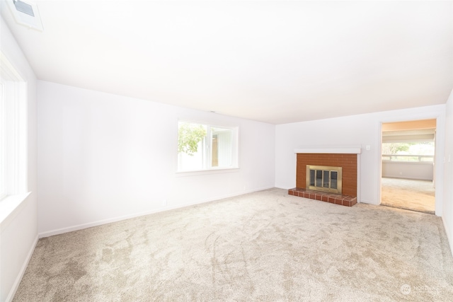 unfurnished living room with a fireplace and light carpet