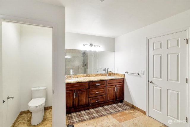 bathroom featuring vanity, tiled shower, and toilet