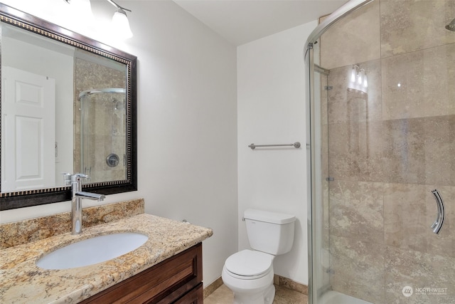 bathroom with vanity, toilet, and an enclosed shower