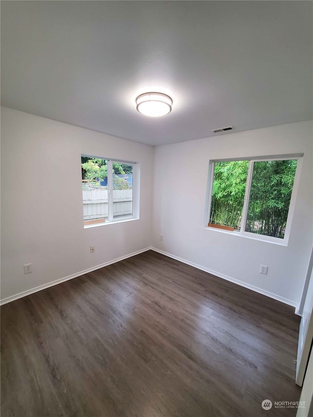 spare room with dark hardwood / wood-style floors