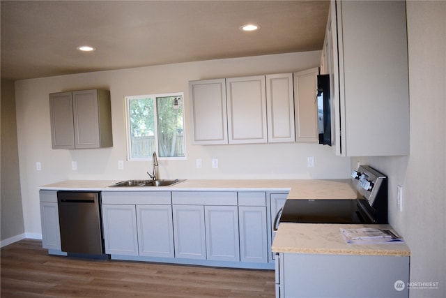 kitchen featuring sink, dishwasher, light wood-type flooring, and gray cabinetry