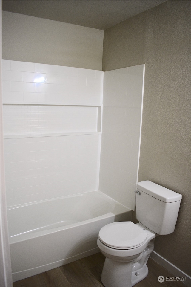 bathroom with toilet, shower / bathing tub combination, and wood-type flooring