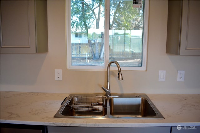 room details with sink, light stone counters, and gray cabinets