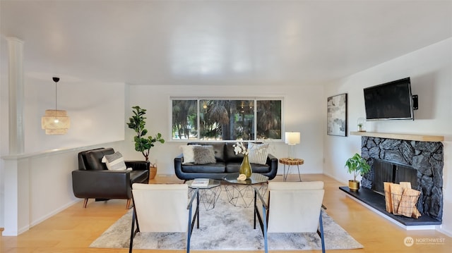 living room featuring a fireplace and light wood-type flooring