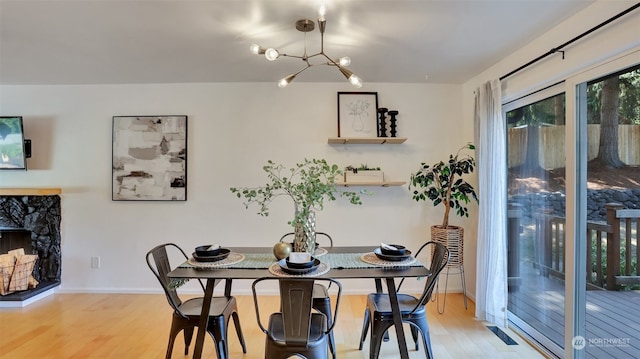 dining space with light hardwood / wood-style floors and a notable chandelier