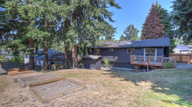 rear view of house featuring a deck and a lawn